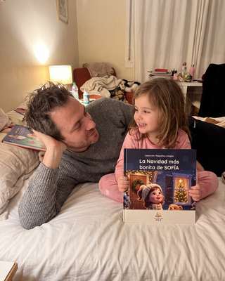 Padre e hija con el cuento sobre la cama